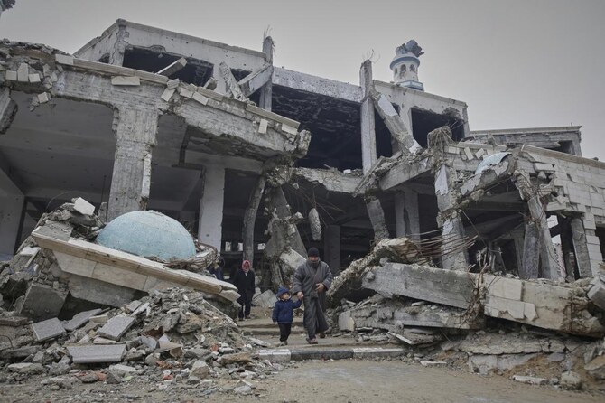 3月7日、ガザ市のツァイトゥーン地区にある、イスラエル軍の空爆で損壊したイマーム・シャフィイ・モスクで、ラマダンの最初の金曜礼拝に出席した後、立ち去るパレスチナ人たち。(AP)