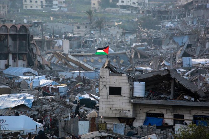 2025年3月4日、イスラエルとハマスの停戦が続く中、ガザ地区北部のベイトラヒアの廃墟の中ではためくパレスチナ国旗。(ファイル/AFP)