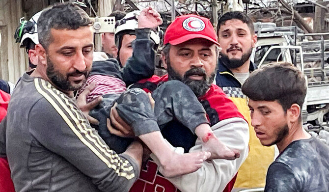 2025年3月15日、シリア西部の沿岸都市ラタキアで、爆発現場から若い犠牲者を救出するシリア市民防衛隊員と救急隊員。(AFP＝時事)