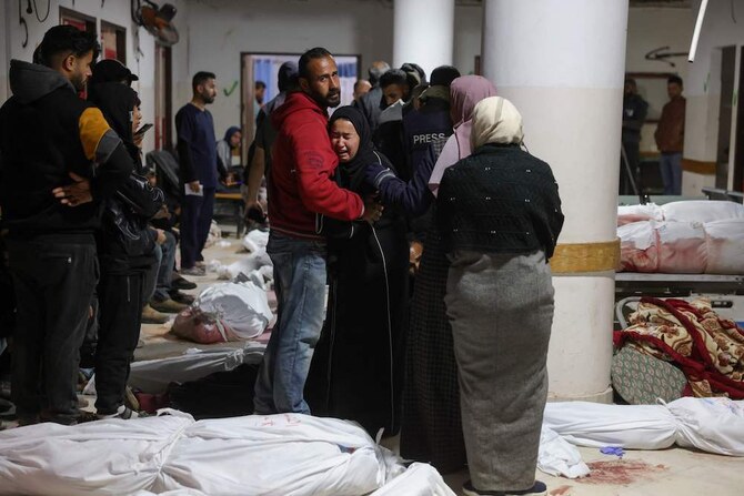 2025年3月20日、ガザ地区北部のベイトラヒアのインドネシア病院で、イスラエル軍による夜間空爆の犠牲者の遺体のそばで追悼するパレスチナ人。(AFP=時事)