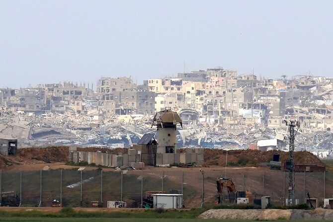 2025年3月20日、破壊された建物を背景に、イスラエルとガザ地区北部の国境沿いに立つ軍の監視塔。(AFP=時事)