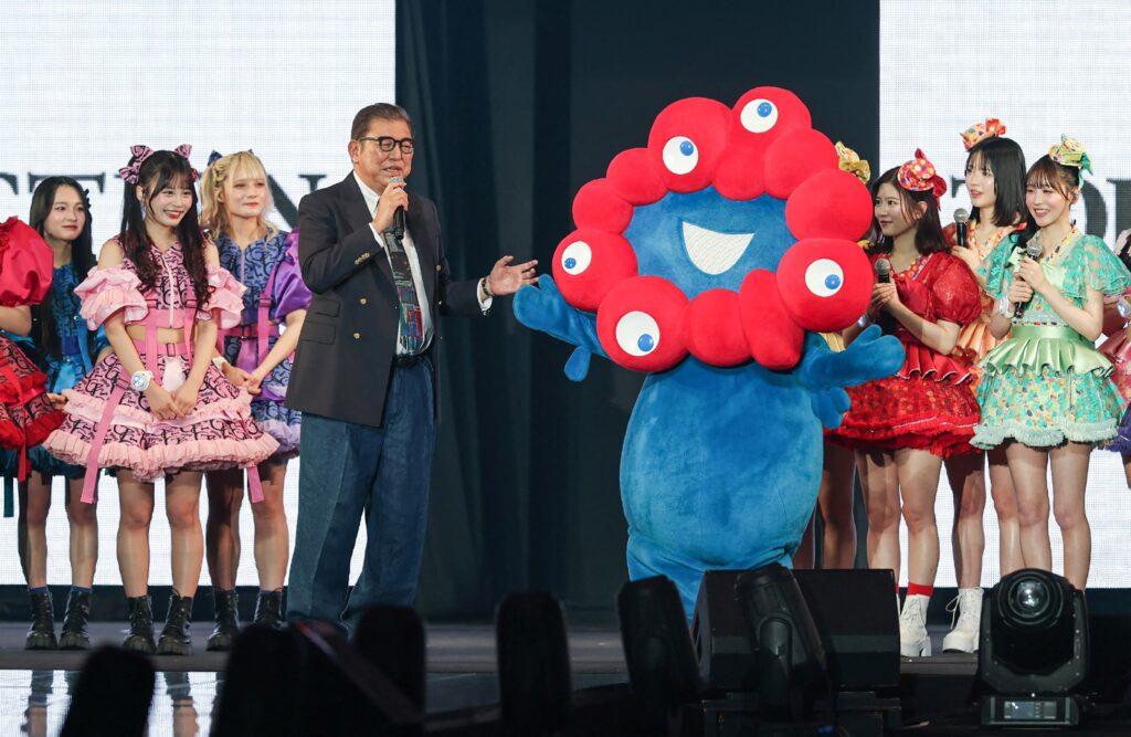 ガールズグループのメンバーに囲まれながら、石破茂首相が東京ガールズコレクションにサプライズ登場した。(AFP)