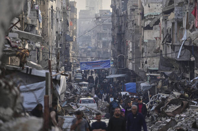 2025年3月25日、ガザ地区のアル・シャティ難民キャンプで、イスラエルの空爆と地上攻撃による破壊の中を歩くパレスチナ人。（AP通信）