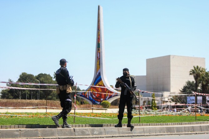 2025年3月15日、ダマスカスのウマイヤ広場で開かれた集会で、シリアの反政府運動14周年を祝う人々を前に展開するシリア治安部隊の隊員たち。(AFP)