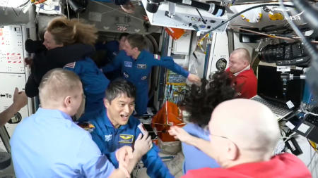 NASAが動画から作成したこの画像は、2025年3月16日(日)、スペースXのカプセルが国際宇宙ステーションにドッキングした後、大西卓哉宇宙飛行士(中央)を含む宇宙飛行士たちが互いに挨拶している様子を示している。(NASA/AP通信