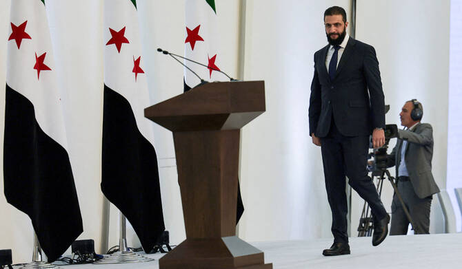 2025年3月29日、シリアのダマスカスで行われたシリア・アラブ共和国政府の閣僚会合で、演説に先立ち歩くアフメド・アル・シャラア暫定大統領。(ロイター)
