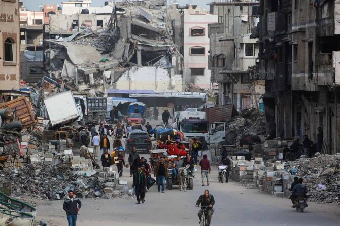 2025年4月11日、イスラエルの避難命令に従い、ガザ市東部の近隣地区からガザ市に避難するパレスチナ人が、持ち物を運んでいる。(AFP)