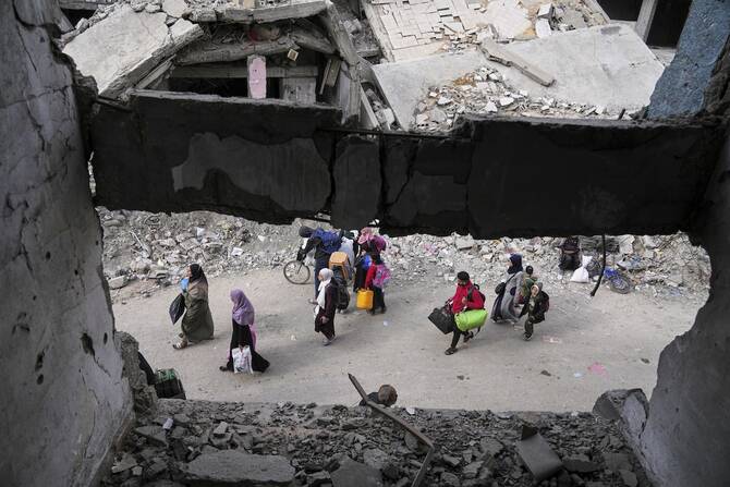 金曜日にイスラエル軍がその地域に避難命令を出したため、避難を余儀なくされたパレスチナ人がガザ市の東から西へと逃げている。(AP通信)