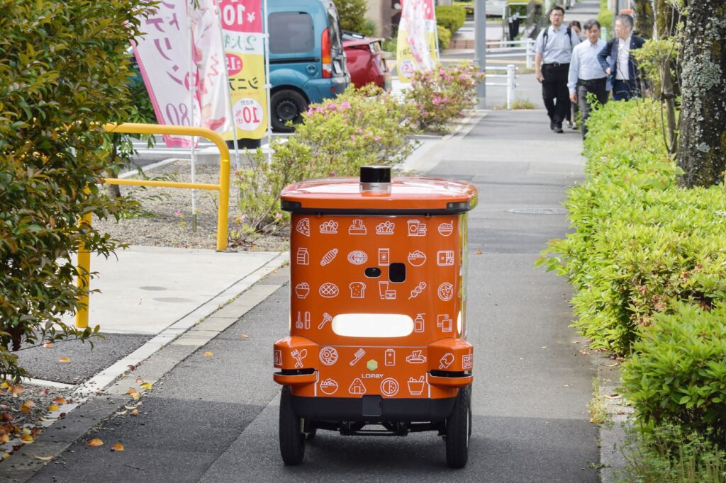 東京・八王子地区で行われたコンビニエンスストア・チェーン、セブン-イレブンの自動配送ロボットによるデモンストレーション。(時事通信/AFP=時事)