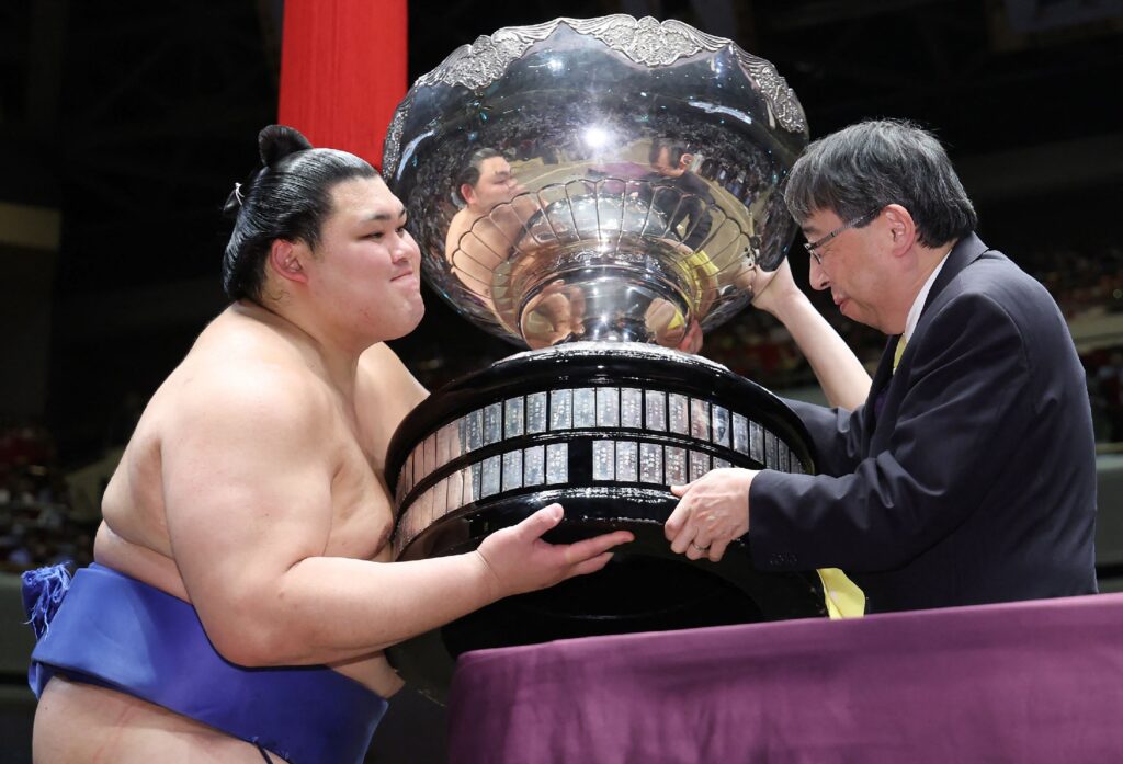 「大相撲夏場所15日目、14勝1敗で4度目の優勝を果たし、内閣総理大臣杯を掲げる大関・大の里（左）。(AFP＝時事)