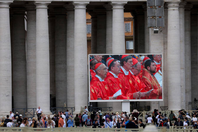 2025年5月7日、イタリア・ローマから見たバチカンのサン・ピエトロ広場で、次期教皇選出のためのコンクラーベ初日に行われた聖ミサを大きなスクリーンで見る人々。(ロイター)