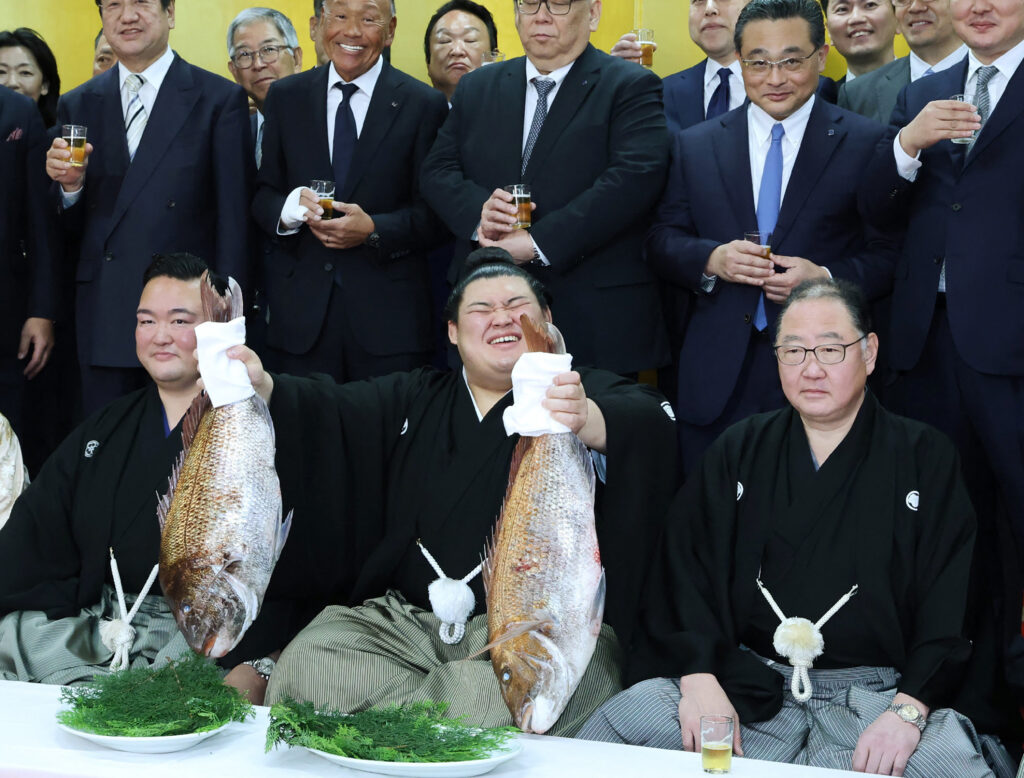 5月28日、茨城県阿見町で行われた大相撲の横綱昇進式後、魚を掲げて喜ぶ力士の大の里(C)。