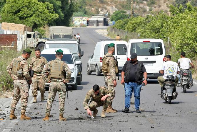 レバノン南部のアブ・アル・アスワドで、イスラエル軍の無人機による自動車を狙った攻撃の後、クレーターを点検するレバノン軍兵士。(AFP=時事)
