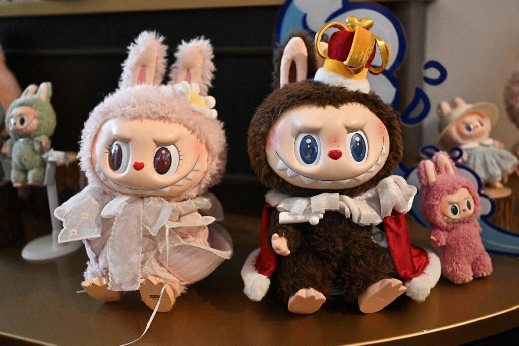 2025年6月18日に撮影されたこの写真は、北京のポップマートのテーマパーク「ポップランド」の展示室にある、キャラクターのモココ(左)とラブブ(右)のフィギュアだ。(AFP)