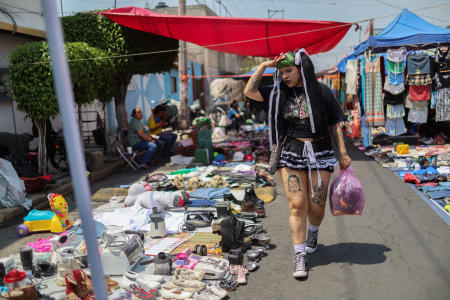 クミコとして知られるメキシコ人デザイナー、イタリア・セゴビア(26)は、メキシコ系アメリカ人のチカーノカルチャーと日本の原宿スタイルを融合させた自身のブランド「チカンジュク」の作品を作るため、古着を購入するストリートマーケットを歩いている(2025年5月21日、メキシコのネサフアルコヨトルにて)。(ロイター)