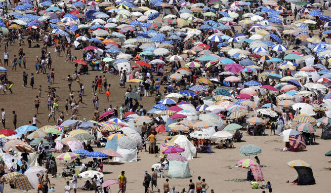 2025年6月29日、ラバトの熱波の中、ビーチで涼む人々。(AFP=時事)