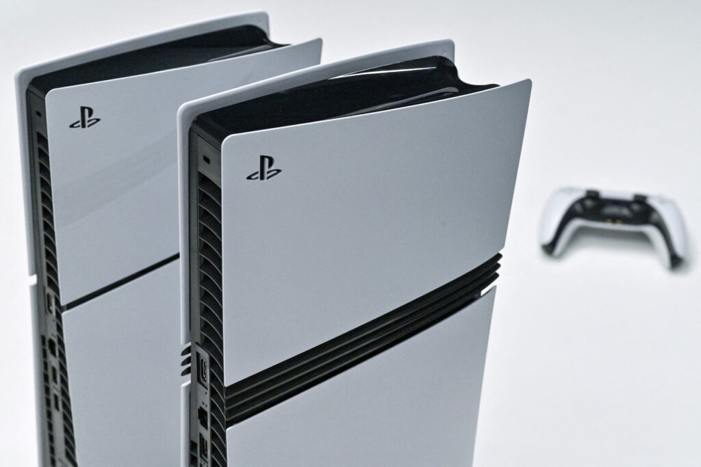 この写真は、2024 年 11 月 27 日、東京中心部のソニー本社ビルに展示された Sony PlayStation 5(左)と 5 Pro(中央)。(AFP)