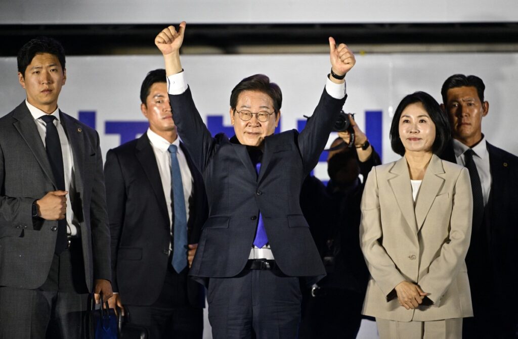 2025年6月4日、ソウルで大統領選挙の最終結果待ちの韓国民主党の李在明(イ・ジェミョン)大統領候補(左)と妻のキム・ヘギョン氏(右)が支持者に手を振る。(AFP)