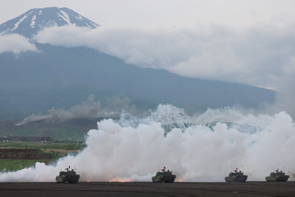 2025年6月8日、静岡県御殿場市の東富士射撃場（左）で、富士山を背景に、陸上自衛隊の戦車が実弾射撃訓練を行っている。（AFP）