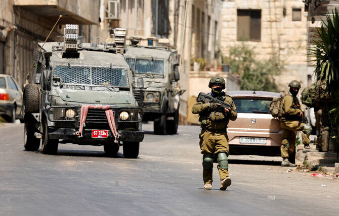 2025年6月10日、イスラエル占領下のヨルダン川西岸地区ナブルスで、イスラエル軍の襲撃に参加するイスラエル兵。(ロイター)