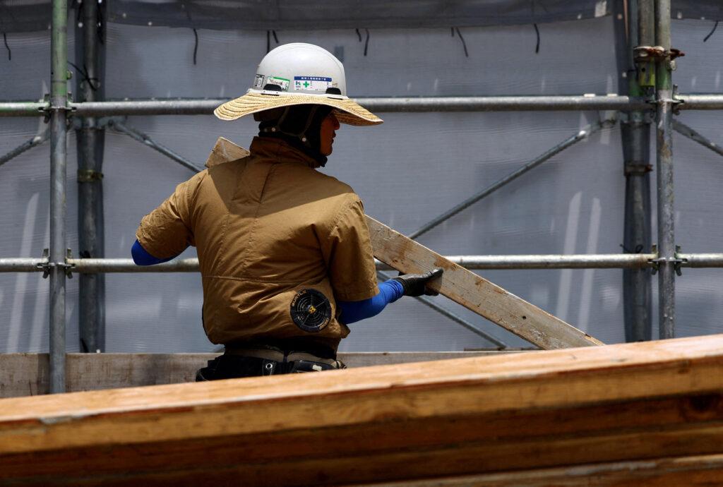 7月7日、東京で建設中のマンションの最上階で、背中に冷却ファンが付いた空調ジャケットを着用した作業員が、暑さの中作業をしている。(ロイター)