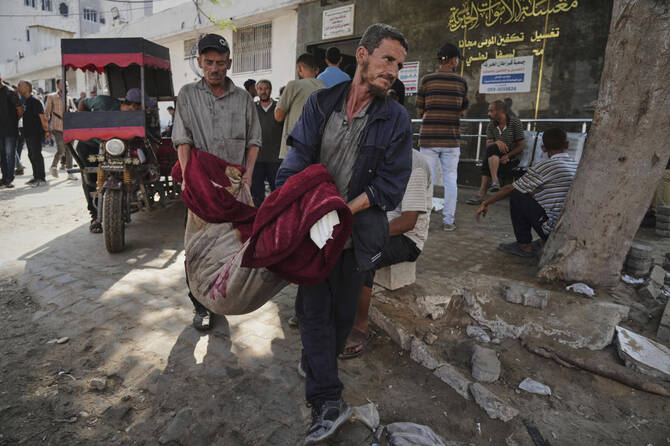 2025年7月22日火曜日、イスラエル軍のガザ空爆で死亡した人の遺体をガザ市のシファ病院に運ぶパレスチナ人。(AP)