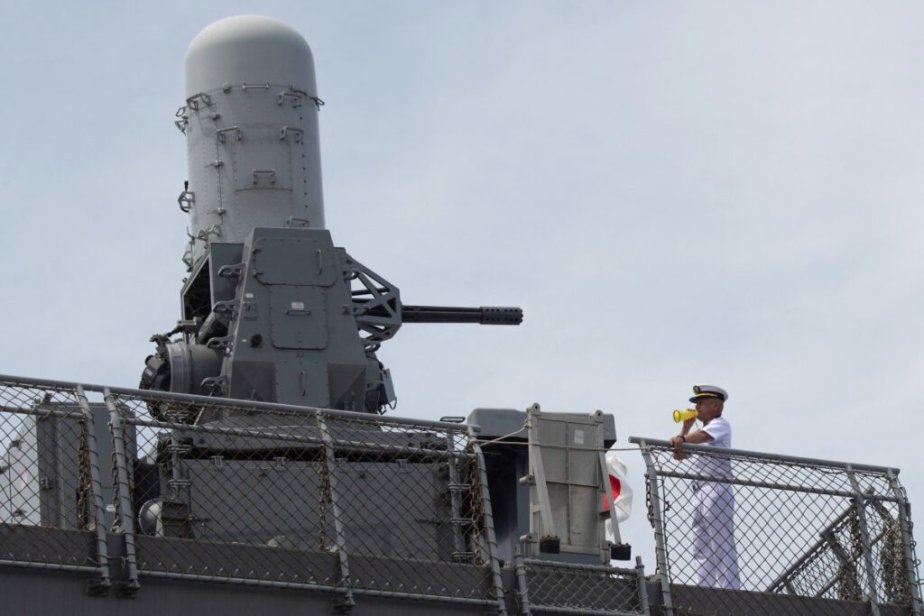 2025年6月21日、マニラの国際港で、海上自衛隊の「ひゅうが」型ヘリコプター搭載護衛艦「いせ」の船員の横に見える20mmファランクス近接武器システム(CIWS)。(AFP=時事)