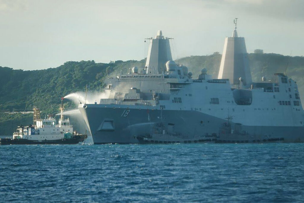 沖縄本島のホワイトビーチ沖で、消火のために放水される米海軍艦船ニューオリンズから上がる煙。(AFP）