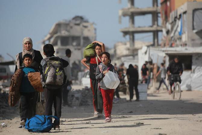 2025年5月19日、イスラエルによる避難命令と攻撃が続く中、ガザ地区北部からガザ・シティに向かって避難するパレスチナ人が、荷物を持ってジャバリアを移動している。(AFP=時事)