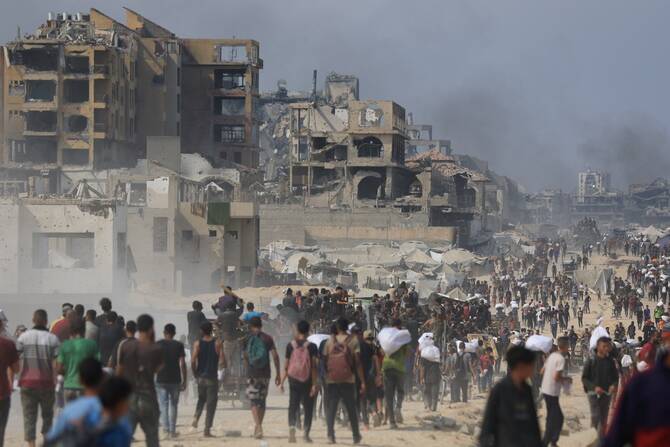 ガザ地区北部のベイトラヒアで、イスラエル経由でガザに入ったトラックから支援物資を求めるパレスチナ人。(ロイター）